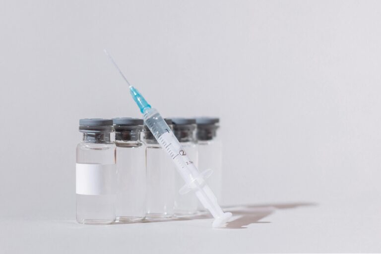 Close-up of vaccine vials with a syringe, emphasizing healthcare and vaccination.